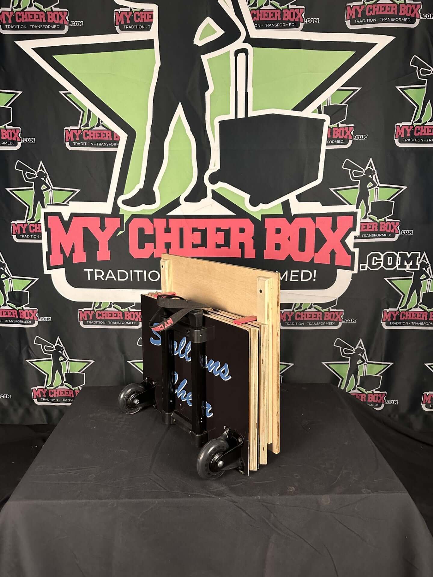 Collapsible 15" cheer box with smooth rolling wheels, rubber gripper feet, and customizable design in front of My Cheer Box backdrop